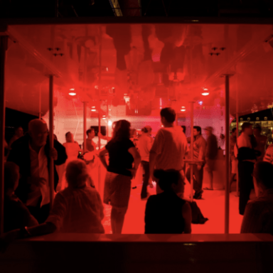 a group of people standing on the dance floor of a boat