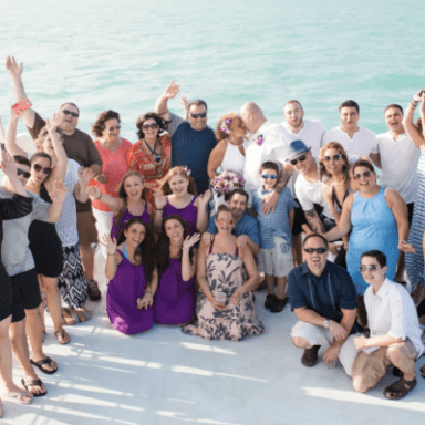 a group of people posing in front of a body of water