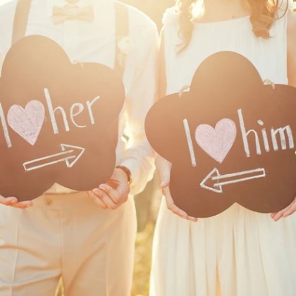 Couple holding I love him and her signs