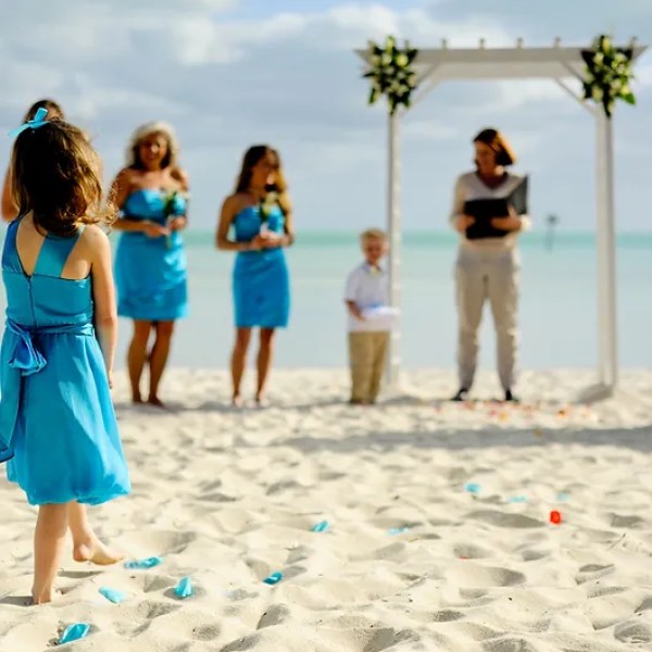 Group of people standing on the beach during a wedding