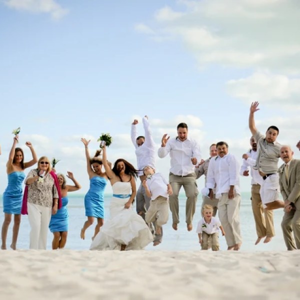 Wedding party jumping on the beach