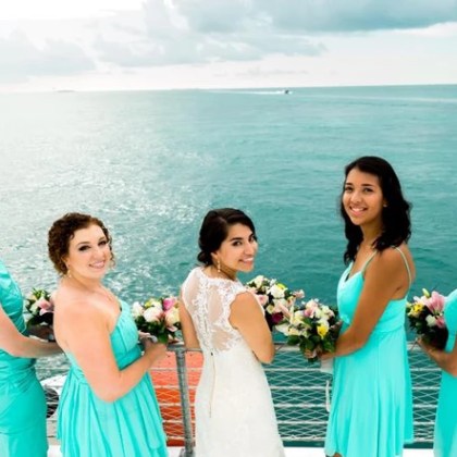 Bridal party posing for a photo on a boat