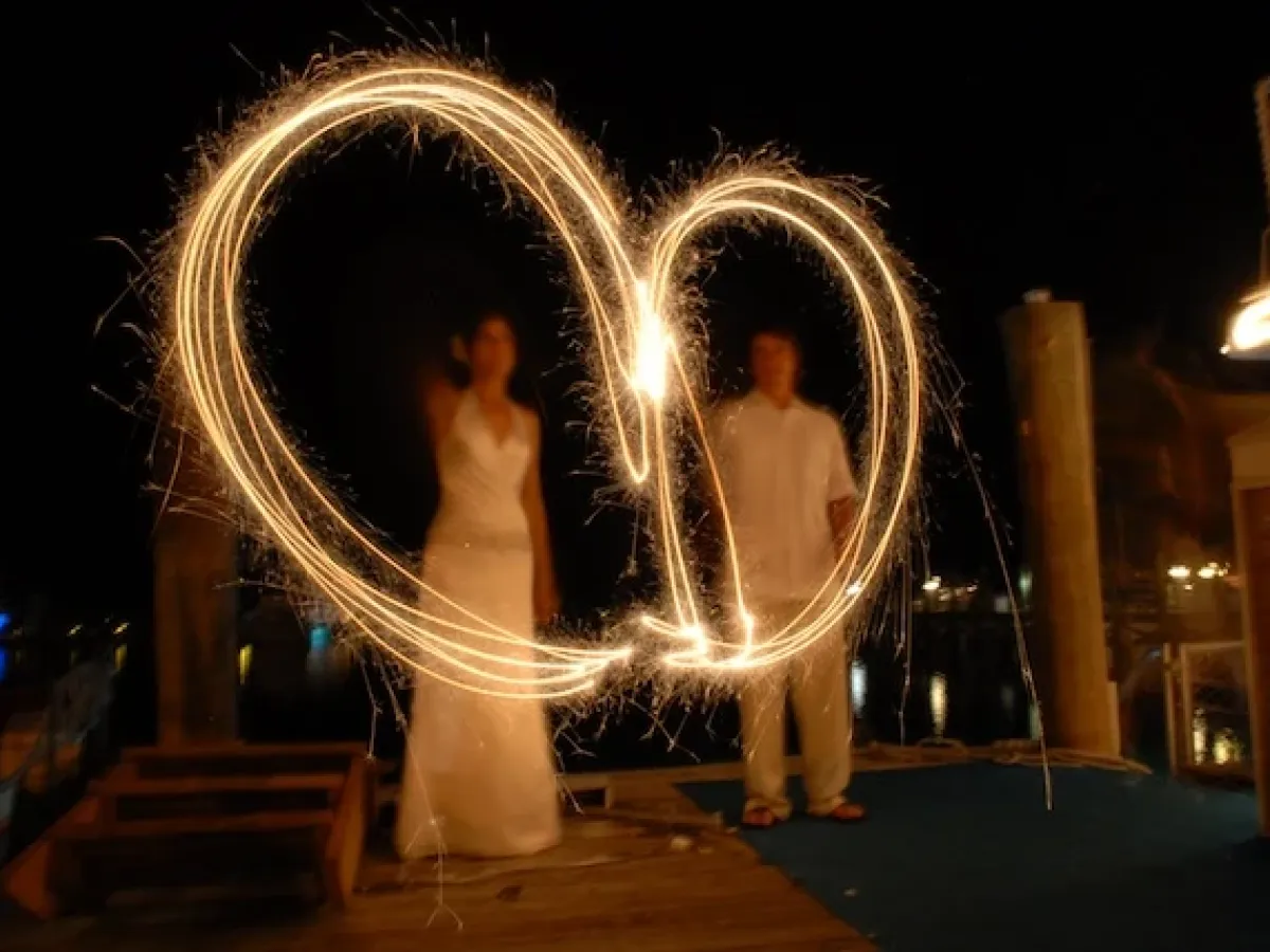 Bride and groom waving sparkler fireworks