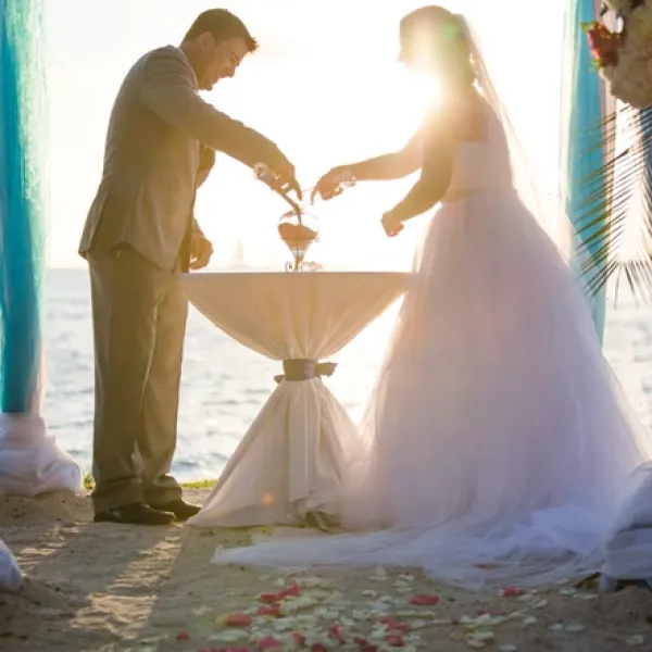 Bride and Groom pouring sand into a vase during a beach wedding ceremony