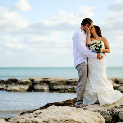 Bride and groom kissing on the beach