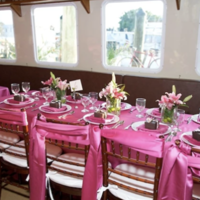 a bunch of pink flowers on a table inside a boat